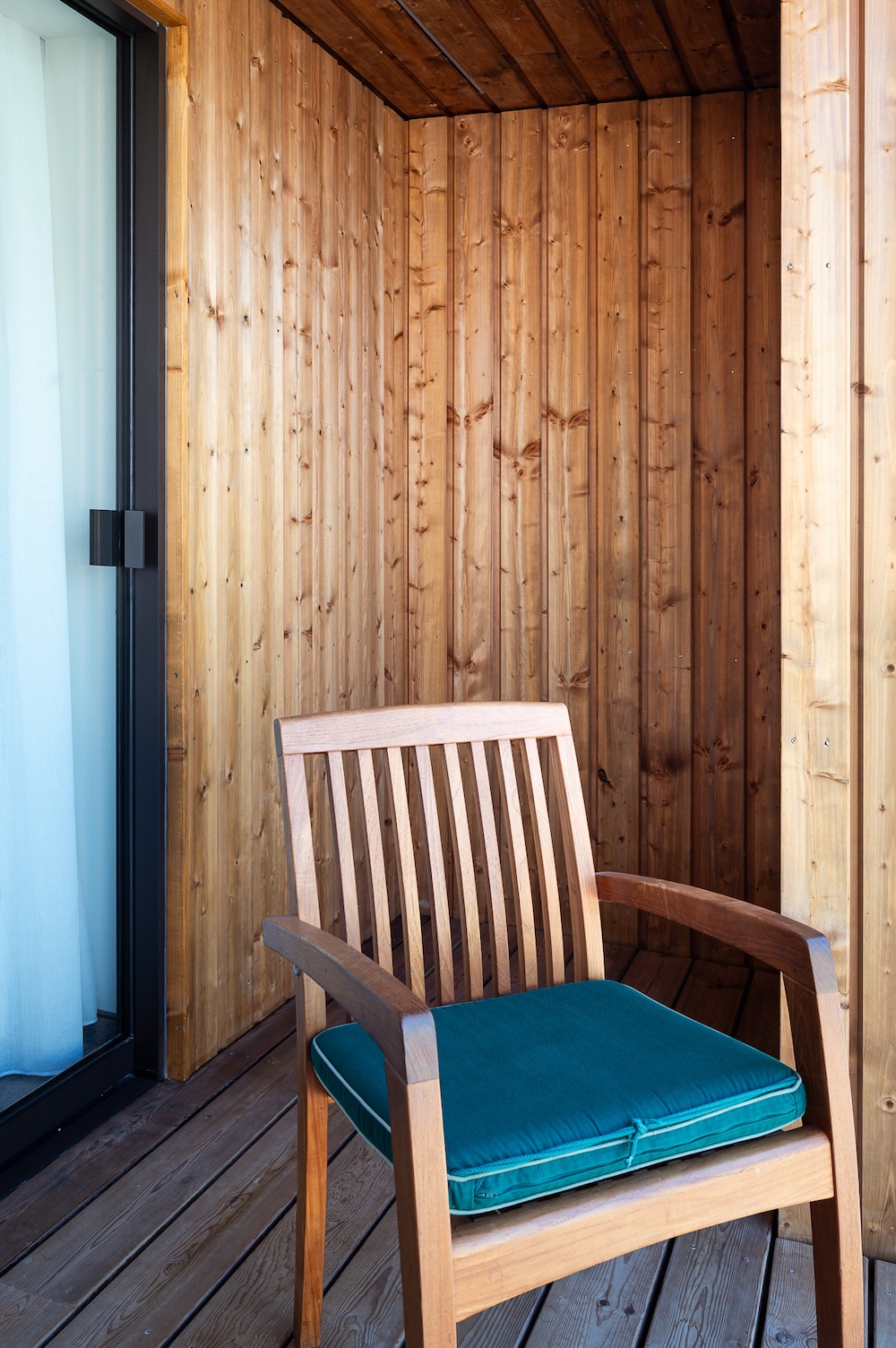 Fauteuil en bois avec coussin bleu sur terrasse en bois